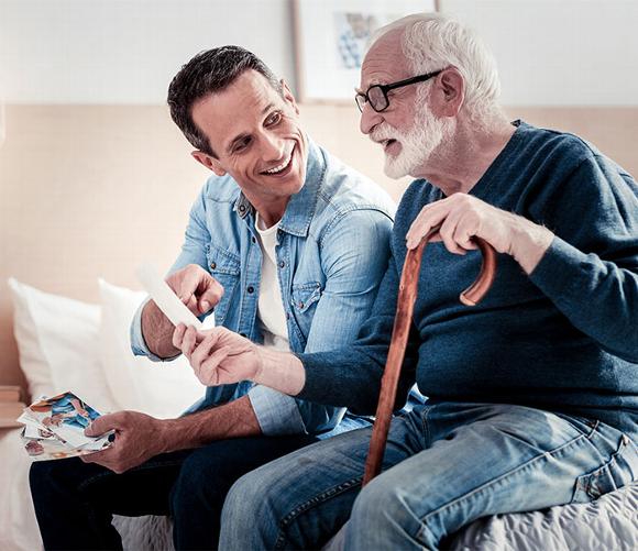 care worker looking at photos with elderly man